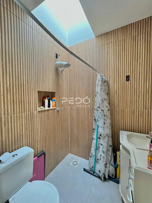 Foto do interior de um banheiro com revestimento de parede de madeira.