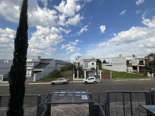 Vista externa de casas em Lajeado, Brasil, com rua e vegetação.