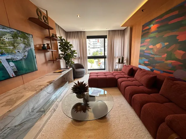 Sala de estar com sofá de cor avermelhada e lareira moderna.