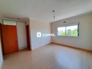 Foto de uma sala com piso de madeira clara e janela.