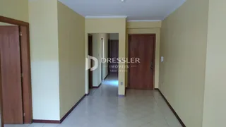 Corredor interno de uma residência com paredes amarelas e piso claro.
