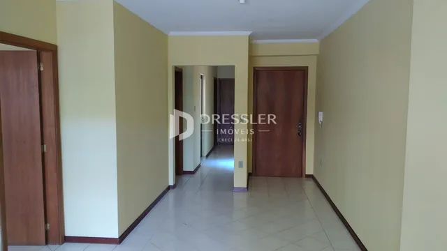 Corredor interno de uma residência com paredes amarelas e piso claro.