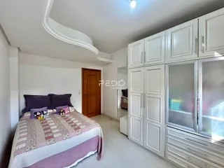 Quarto com armários brancos e piso de madeira clara.