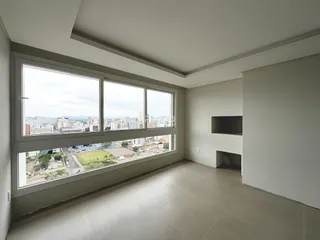 Sala de estar com grandes janelas oferecendo vista da cidade.
