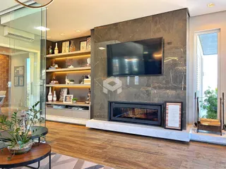 Sala de estar moderna com lareira e painel de TV em um imóvel no Brasil.
