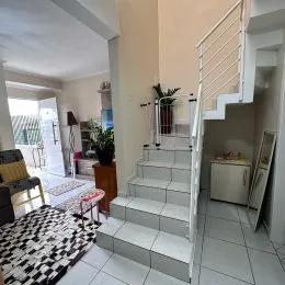 Foto de um corredor com escadas brancas em um imóvel.