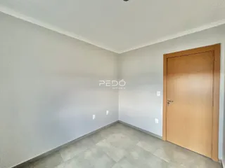 Vista interna de um ambiente com paredes brancas e piso claro.