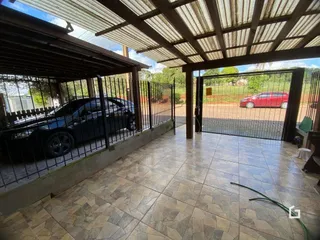 Área externa coberta com piso de cerâmica e grade de metal.