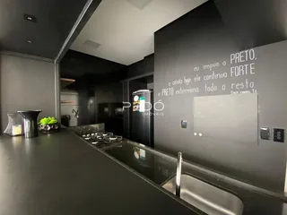 Vista da cozinha moderna com bancada escura e pia.