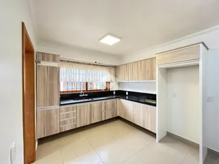 Foto de uma cozinha com armários de madeira e piso claro.