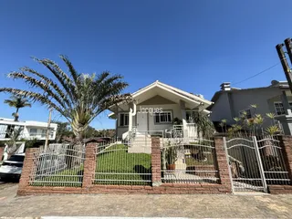 Fachada de uma casa em Lajeado, Brasil, com cerca e jardim na frente.