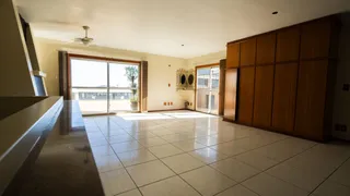 Ambiente interno de uma sala ampla com piso de cerâmica.