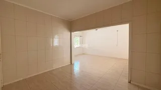 Hall de entrada com piso de cerâmica claro e paredes brancas.