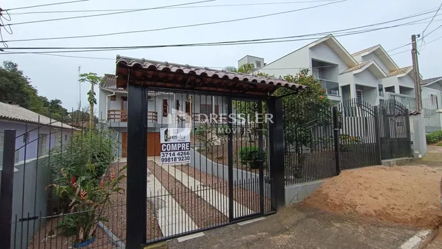 Fachada de uma residência com portão de ferro na Lajeado.