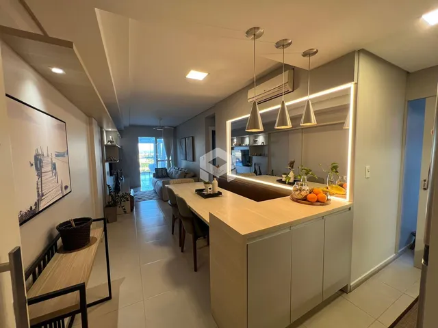 Ambiente interno de uma sala de estar com ilha de cozinha moderna.