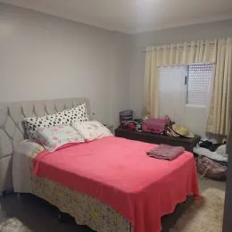 Quarto com cama e paredes brancas em um imóvel.