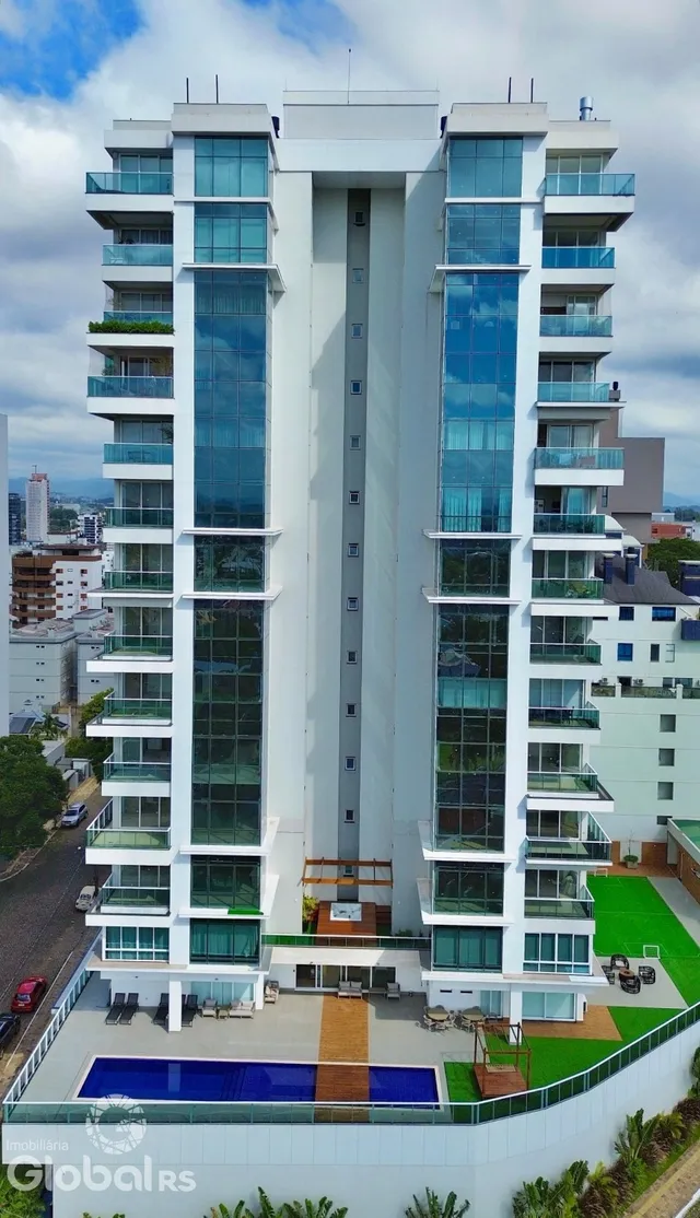 Fachada de um prédio residencial moderno em Lajeado, Brasil, com piscina e varandas.