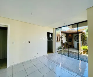 Interior de uma sala com piso de cerâmica e porta de vidro que dá para o quintal.