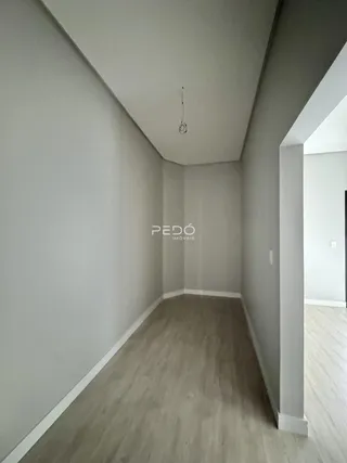 Hall de entrada com paredes cinzas e piso de madeira clara.