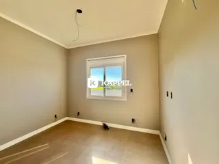 Foto de um cômodo interno com paredes neutras e uma janela.