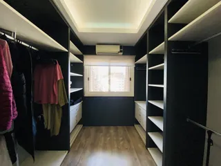 Corredor com armários embutidos e estantes laterais.