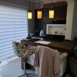 Foto de um quarto interno com cortinas brancas e móveis.