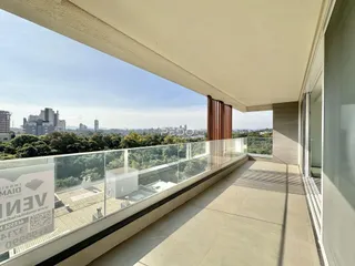 Vista panorâmica da cidade e da vegetação a partir de uma varanda.
