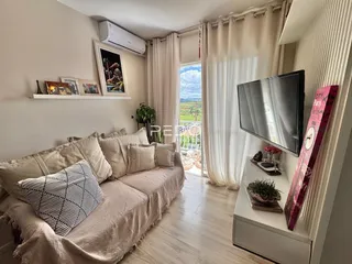 Sala de estar com sofá e grandes janelas.