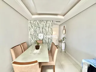Sala de jantar com mesa e cadeiras em um ambiente claro com parede decorada.