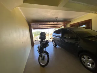 Interior de uma sala com teto de madeira e uma motocicleta estacionada.