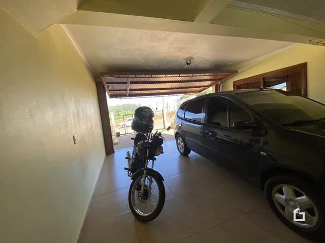 Interior de uma sala com teto de madeira e uma motocicleta estacionada.