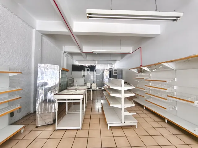 Interior de uma cozinha com prateleiras de metal e piso de cerâmica.