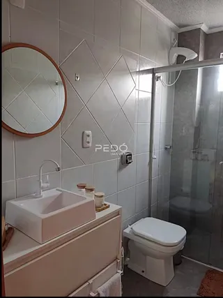 Foto de um banheiro com revestimento de azulejos brancos e box de vidro.