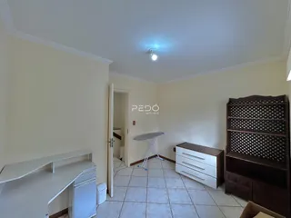 Ambiente interno de uma sala com piso de cerâmica e paredes claras.
