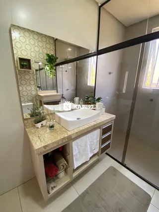 Banheiro com bancada de pedra clara e armários embutidos.