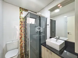 Foto de um banheiro com box de vidro e pia.