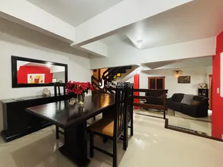 Hall de entrada com mesa de jantar e escadaria em um imóvel no Brasil.