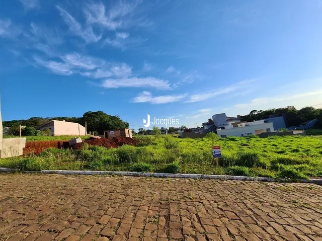 Vista externa de um terreno gramado sob um céu azul claro.