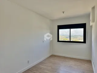 Sala de estar com paredes brancas e piso de madeira clara.