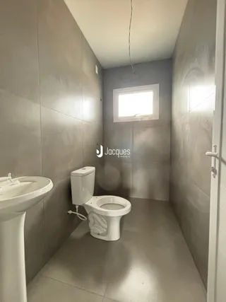 Corredor interno mostrando um vaso sanitário e pia