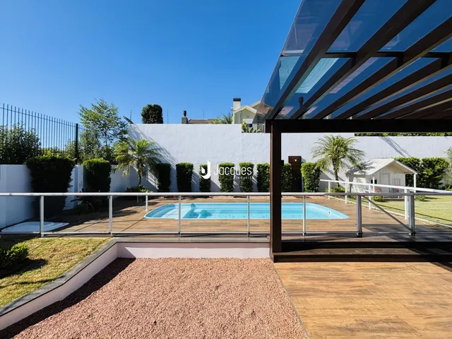 Vista externa de uma piscina e deck em uma propriedade no Brasil.