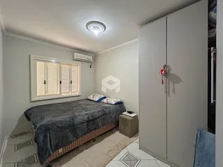 Quarto com cama e armário branco em um imóvel no Brasil.