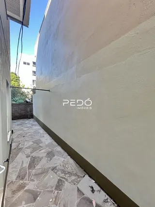 Parede externa de um imóvel em Lajeado, Brasil, com piso de pedra.