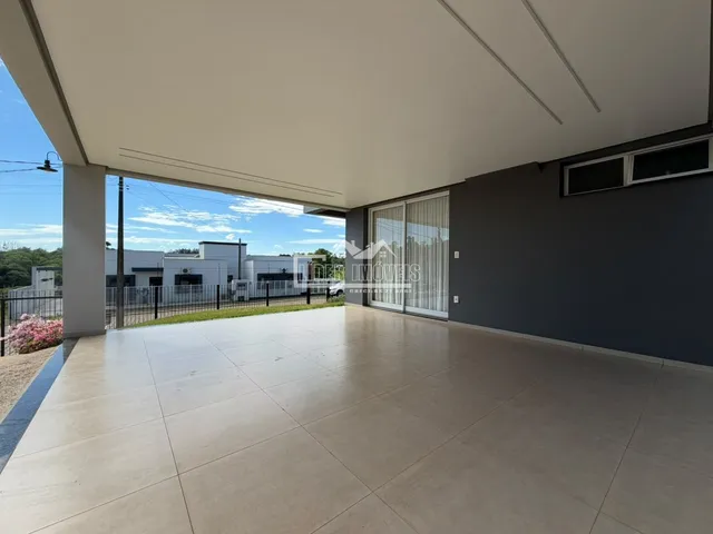 Vista da área externa com piso de cerâmica e portas de vidro.