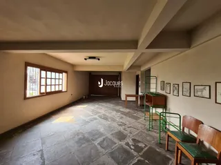 Interior de uma sala com piso de concreto e paredes claras.