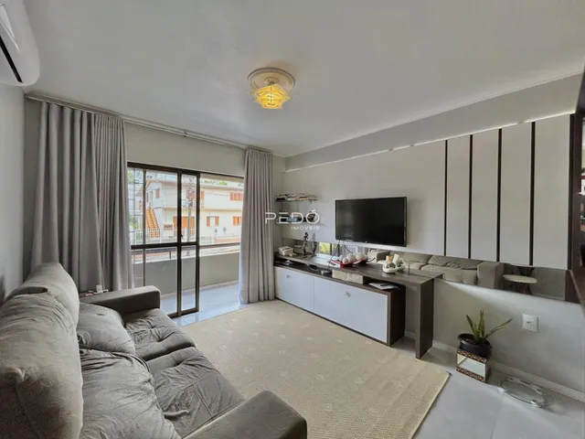 Sala de estar com sofá e vista para o exterior em Lajeado.