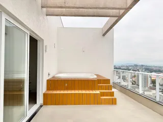 Varanda com banheira em madeira e vista panorâmica da cidade.