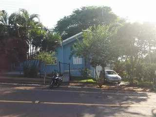 Fachada de uma residência azul em Lajeado, Brasil, com vegetação ao redor.