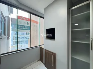 Vista interna de um ambiente com grande janela que oferece uma visão da fachada.