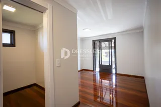 Interior de um corredor com piso de madeira polida.
